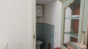 A bathroom with a toilet, a sink, and a water heater. - Sandra's House in Meta di Sorrento (Meta)