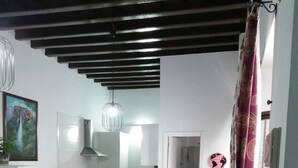 A compact living space with a kitchen, dining area, and a red armchair with a patterned cushion. - Study Cádiz center, meters with air conditioning. Up to 5 people (Cádiz)