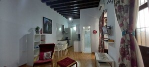 Ein kompakter Wohnraum mit Essbereich, Küche und kleinem Arbeitszimmer.