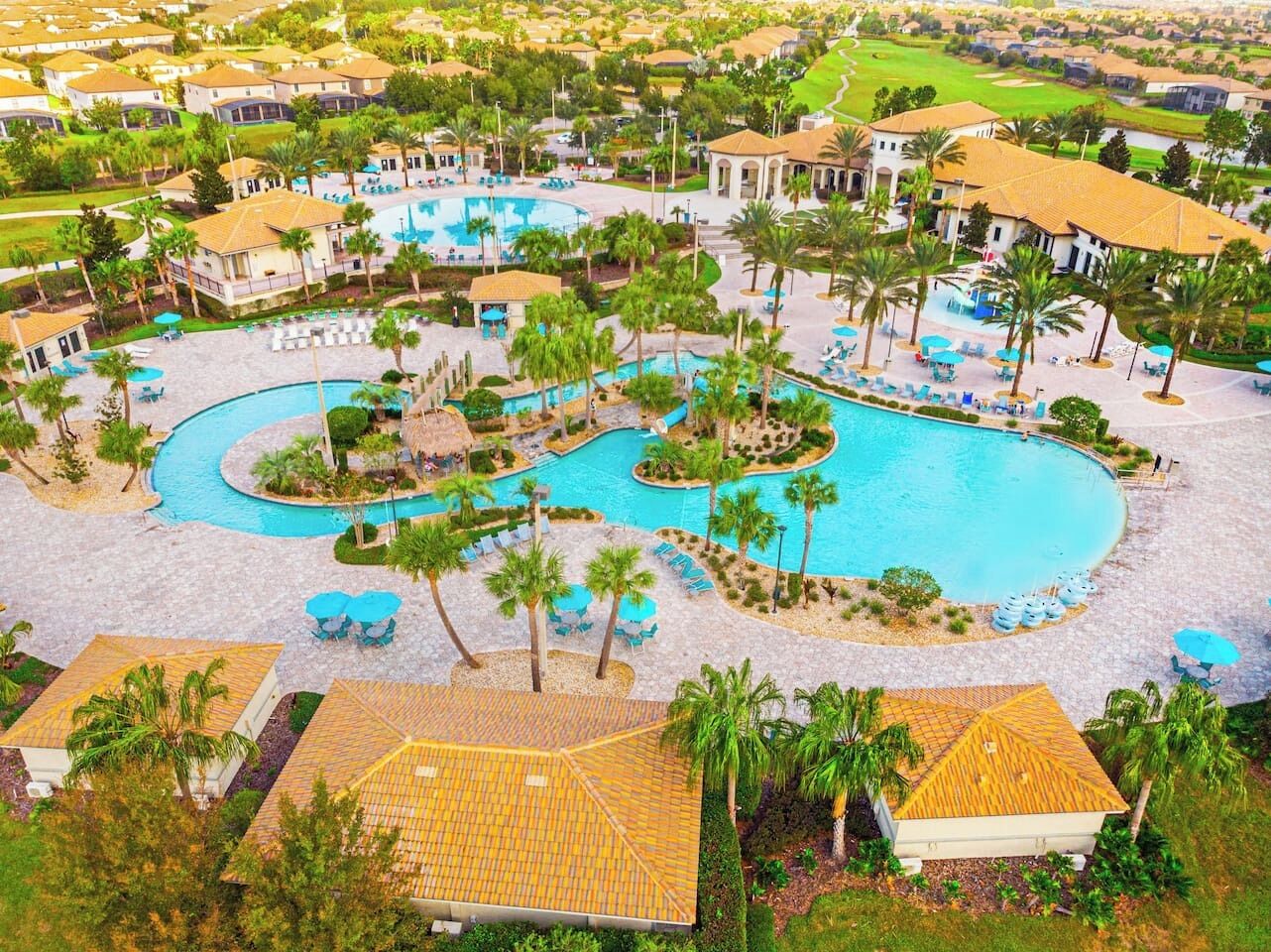 A resort with multiple swimming pools, palm trees, and lounge areas.