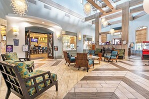 A spacious lobby with a high ceiling, a reception desk, and comfortable seating areas. - 1upRetreat - Mario Private Pool Lazy River Disney (Davenport)