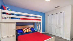 Uma cama beliche com colchão vermelho, parede azul e porta branca.