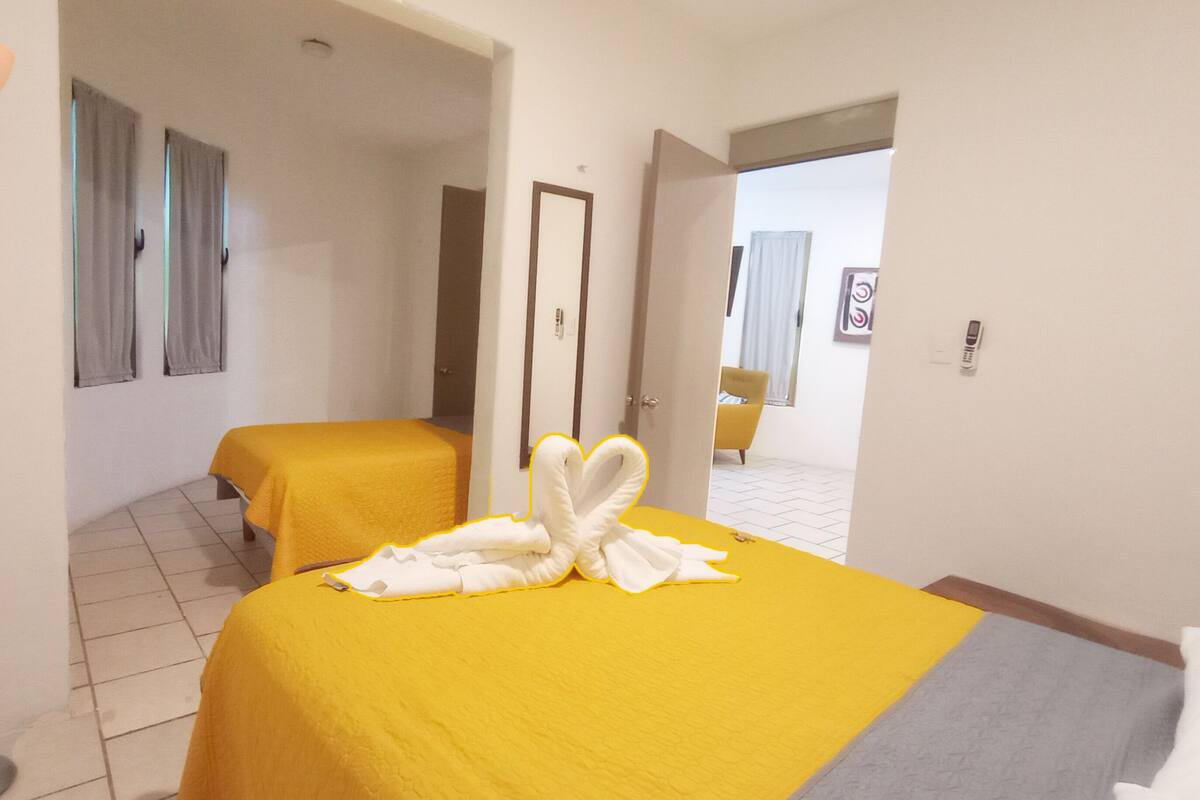 Une chambre d’hôtel avec deux lits, un bureau et une chaise.