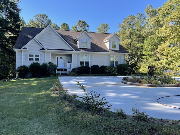 A two-story house with a front porch, a driveway, and a well-maintained lawn.