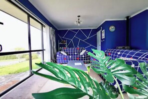 Relax in a stylish room with a geometric-patterned sofa, large window, and a potted plant.