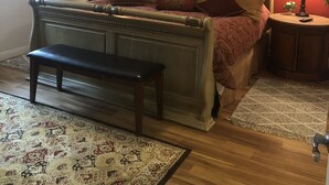 A bedroom with a bed, two bedside lamps, a bench, a ceiling fan, and a window with curtains. - Peaceful and tranquil townhouse for seniors  Heated pool/Spa gym. covered patio (Mesa)