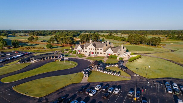 A large, historic building with a symmetrical facade, surrounded by a golf course and parking areas. - Condo in Legends Golf Course Resort  with a great Pub Next Door to the Unit (Myrtle Beach)