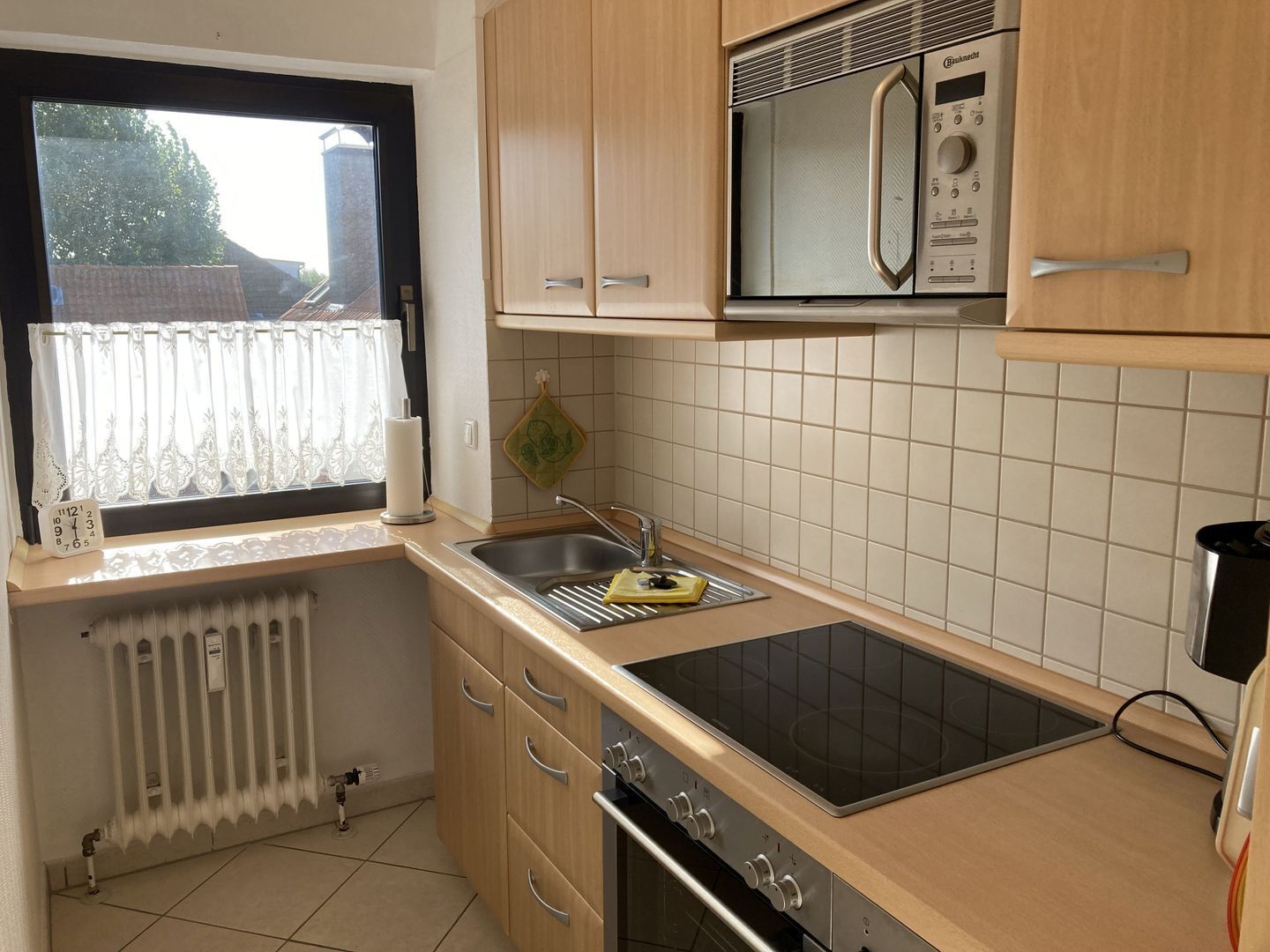 A compact kitchen with a built-in microwave, a sink, and a stove.