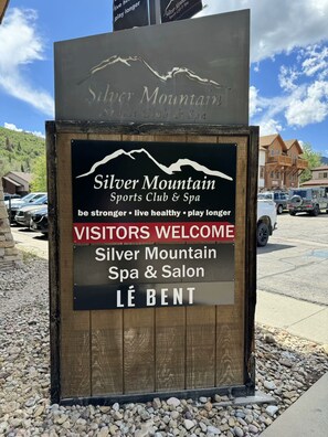 Señal para Silver Mountain Sports Club & Spa con un mensaje de bienvenida y la silueta de una montaña.