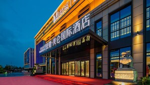 A hotel with a modern facade, illuminated signage, and a prominent entrance. - Grand Madison Hongjian Zhongchuan Airport (Lanzhou)