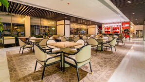 A spacious indoor area with multiple seating arrangements, including tables and chairs, and a visible store with shelves in the background. - Grand Madison Hongjian Zhongchuan Airport (Lanzhou)