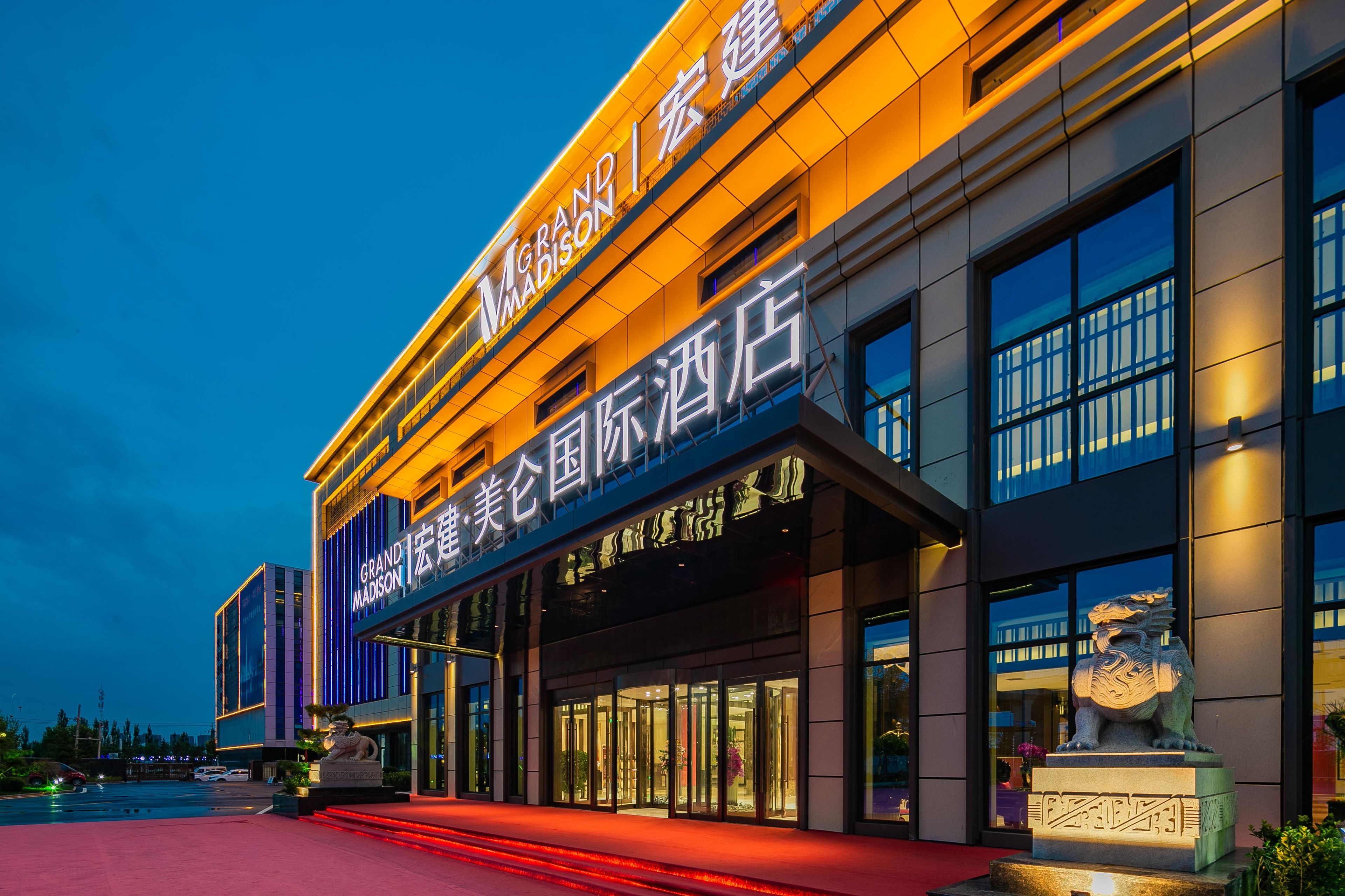 A hotel with a modern facade, illuminated signage, and a prominent entrance.