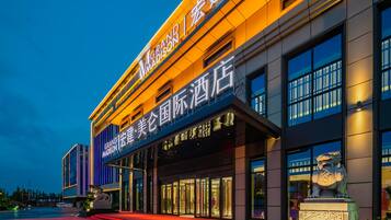 A hotel with a modern facade, illuminated signage, and a prominent entrance.