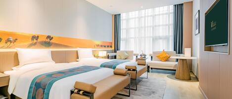 Une chambre d’hôtel avec un grand lit, un canapé, une petite table et un téléviseur fixé au mur.