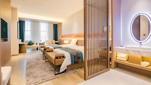 A hotel room with a bed, seating area, and a bathroom with a mirror and sink. - Grand Madison Hongjian Zhongchuan Airport (Lanzhou)