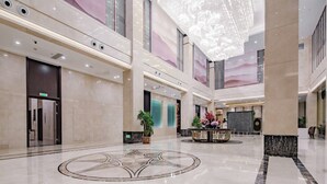 A spacious lobby with a large chandelier, a reception desk, and a circular floor design. - Grand Madison Xuchang Beihai (Xuchang)
