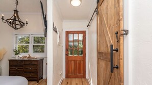 A bedroom with a bed, dresser, and window. - Cozy Mountain Cabin w/ hot tub and fire pit (Boone)