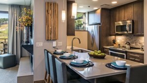 A modern kitchen with dark wood cabinets, stainless steel appliances, and a central island with seating.