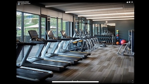 A gym with multiple treadmills, weight benches, and exercise balls.