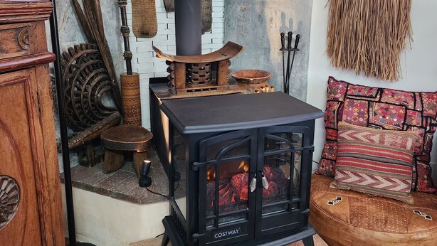 Una camera accogliente con stufa a legna, mobili rustici e una parete decorativa.
