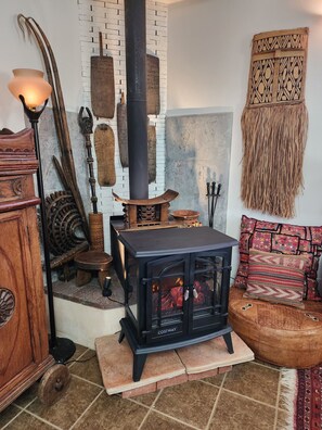 Una habitación acogedora con estufa de leña, muebles rústicos y un adornado en la pared.