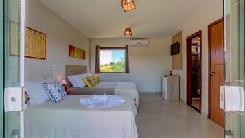 A hotel room with two beds, a TV, a window with curtains, and a door.