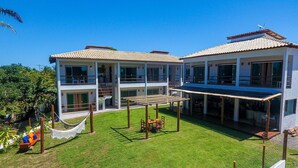 Un edificio de dos pisos con un balcón y un patio cubierto.
