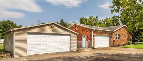 A two-car garage attached to a brick house with a single garage door and a small attached garage.