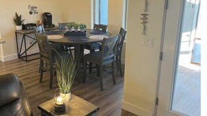 A dining area with a round table, chairs, a coffee machine, and a potted plant. - Quiet, Cozy Three Bedroom Two Bath Home, Great Location (Page)
