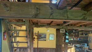 A spacious interior with a wooden staircase, a dining area, and a kitchen. - Rustic two bedroom cottage on riverside in Shohola PA (Shohola)