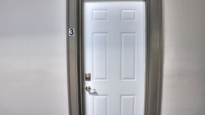 Eine weiße Tür mit der Nummer 3 an der linken Wand.