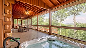 A wooden cabin with a hot tub, large windows, and a deck overlooking a forest. - Large Deck, Screened Porch, Hot Tub, Fire Pit (Morganton)