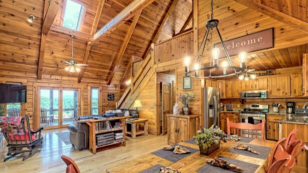 A spacious wooden cabin with a dining area, kitchen, and a cozy living room. - Large Deck, Screened Porch, Hot Tub, Fire Pit (Morganton)
