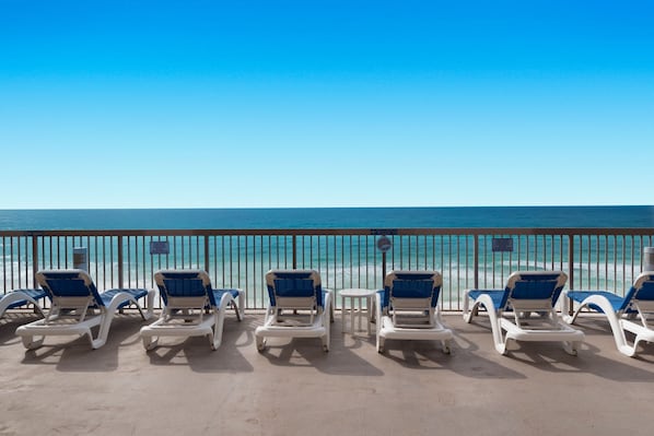 A beachside lounge with sun loungers and a view of the ocean. - ENDLESS GULF VIEWS WITH WRAPAROUND BALCONY! (Panama City Beach)