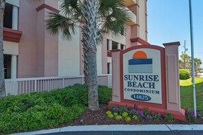 A sign for Sunrise Beach Condominium with a number 14825.