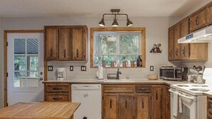 Una cocina compacta con armarios de madera, microondas integrado y lavavajillas.