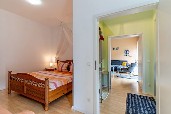 A bedroom with a wooden bed, a bedside table, and a canopy.