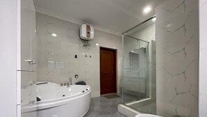 A modern bathroom with a freestanding bathtub, a glass-enclosed shower, and a standard sink.