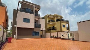 A modern multi-story building with a flat roof terrace and a medical device on the ground floor.