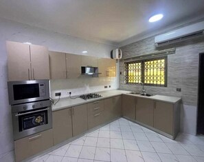 Una cocina moderna con electrodomésticos integrados, estufa a gas y microondas.