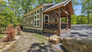 A cabin with a covered porch, multiple windows, and a stone foundation. - Menlo GA Tiny Home Experience! Beautiful Drive (Menlo)