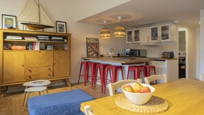A compact kitchen with a wooden table, a bowl of fruit, and red bar stools. - Cavalaire sur mer Mas Boubanette (CAVALAIRE SUR MER)