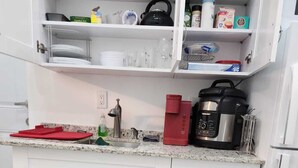 A compact kitchen with white cabinets, a granite countertop, and various appliances including a blender, toaster, and kettle. - Private studio with working space, in Lake Worth Beach (Lake Worth)