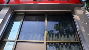 A building facade with large windows and a red sign with Chinese characters.