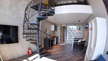 A modern interior with a spiral staircase, a dining area, and a kitchen.