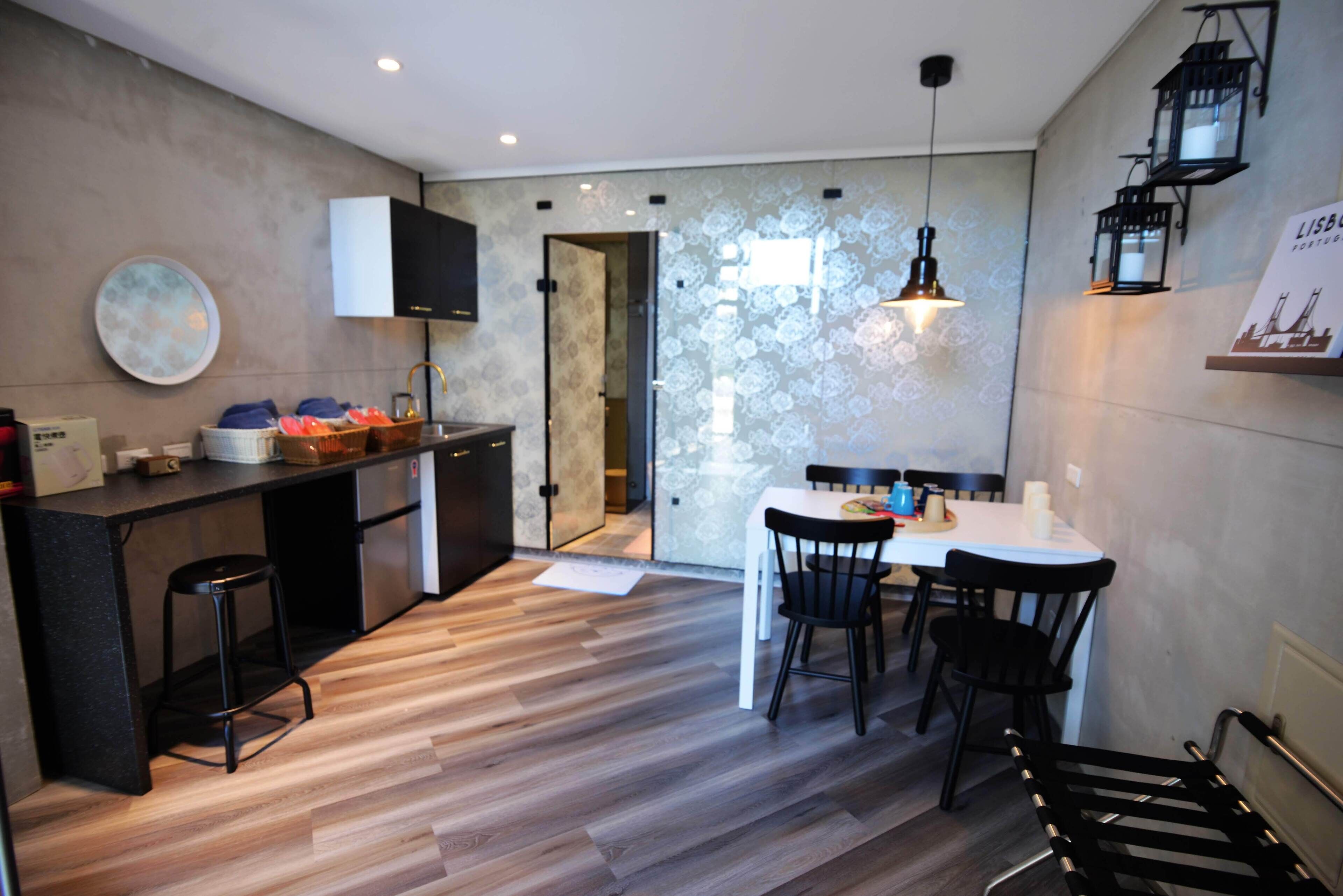 Una cocina moderna con comedor, suelo de madera y vista al espacio de la sala.