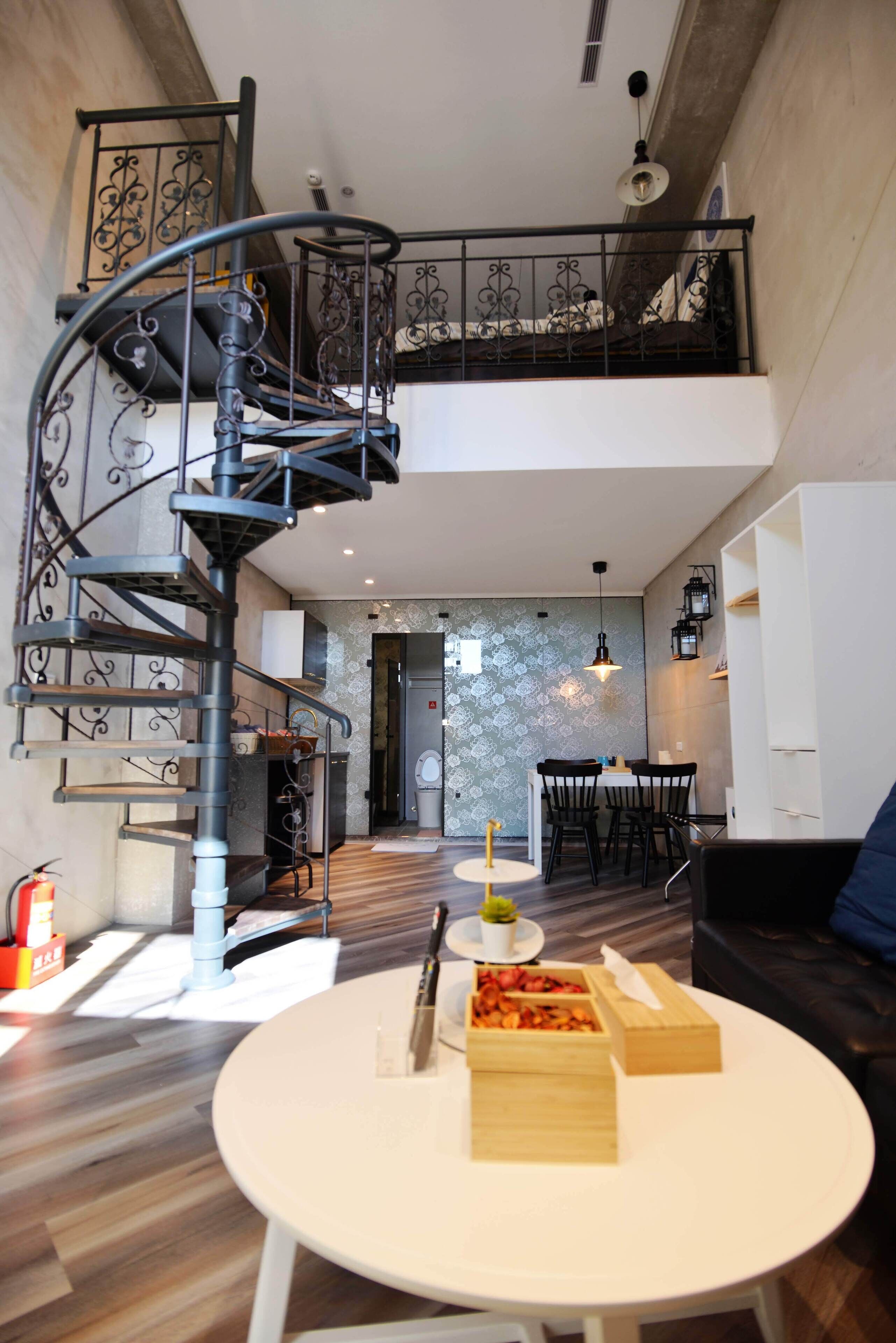 A modern interior with a spiral staircase, a dining area, and a seating space.