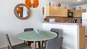 A modern kitchen with a central island, wooden cabinets, and a microwave.