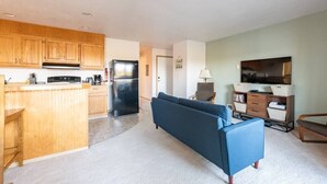 Un apartamento moderno con cocina, sala de estar y televisor.