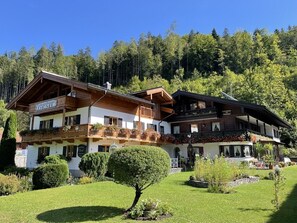 A traditional chalet-style hotel with multiple balconies and a well-maintained garden. - Apartment No. 6 with a balcony and a breathtaking view of the mountains (Berchtesgaden)